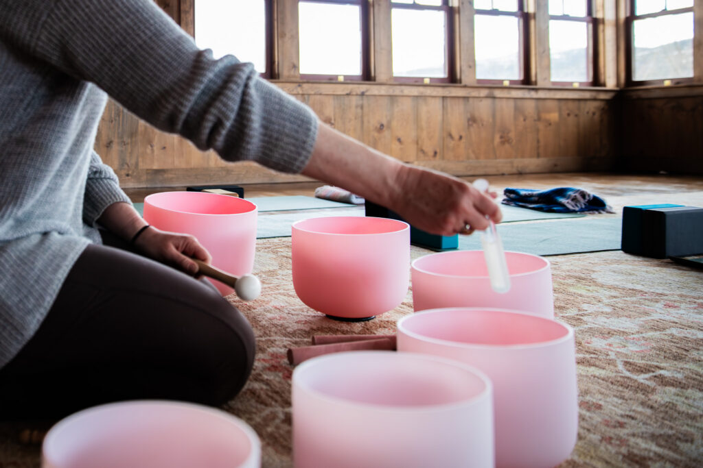 Person plays sound bowl with yoga mats in the background