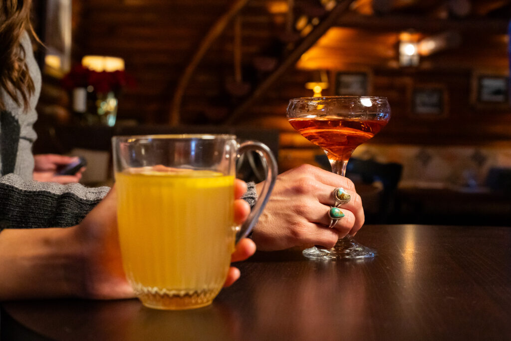 2 hands wrapped cocktails resting on a table in a restaurant. 